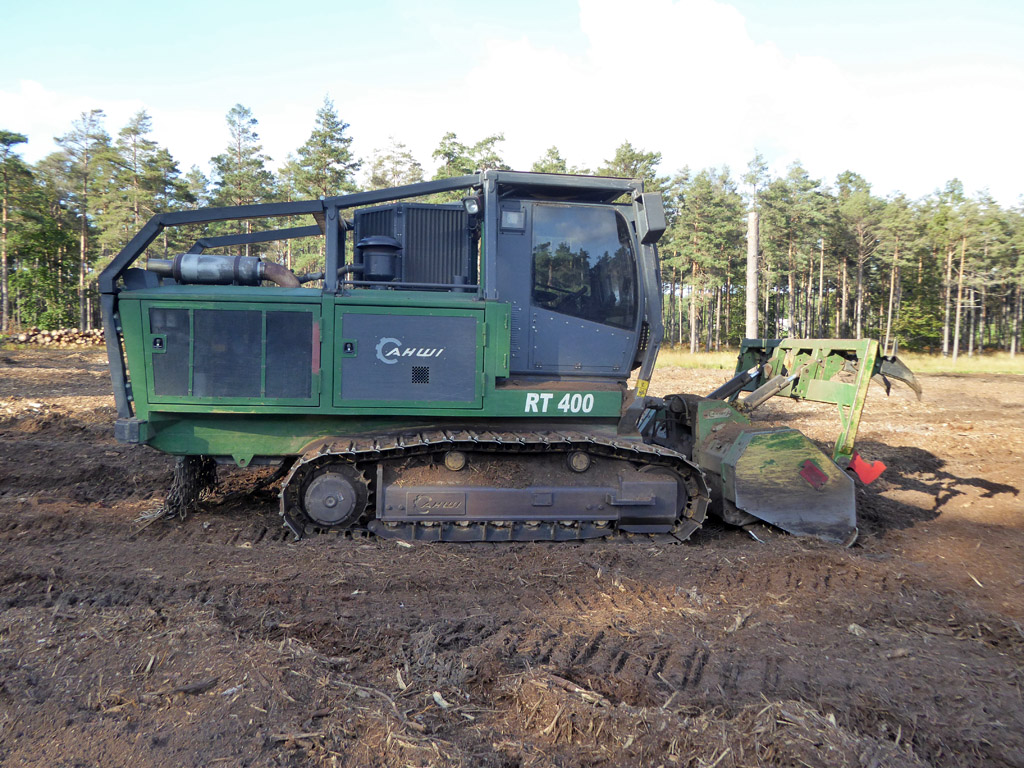 Tracked forestry mulcher staged on a wooded property jobsite