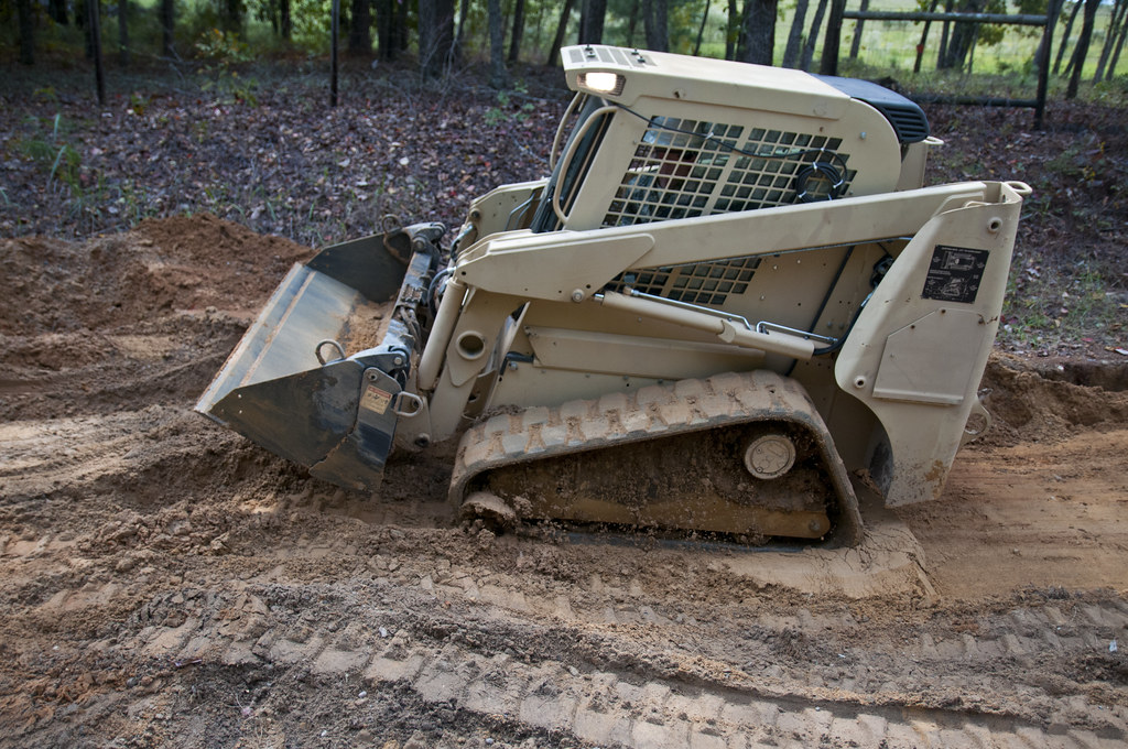 Track loader grading a building pad in the woods